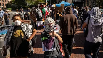 Masked anti-Israel protesters at Columbia University demonstrate as students check in for first day of classes